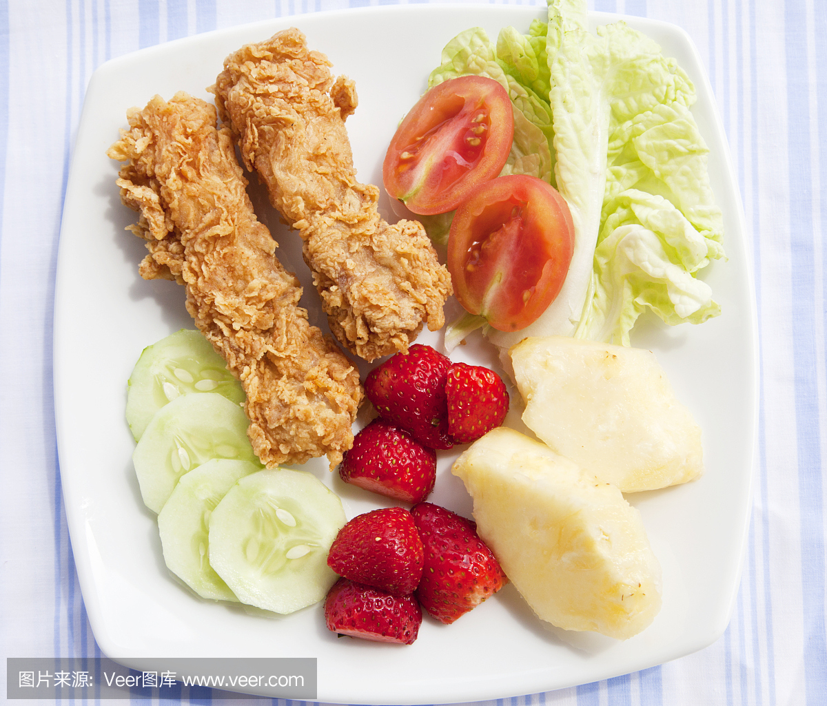 零食。鸡肉,水果和蔬菜放在白色的盘子里。